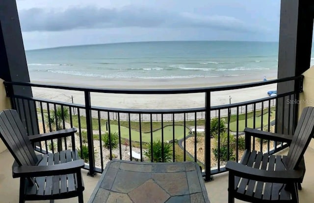 balcony with a water view and a beach view