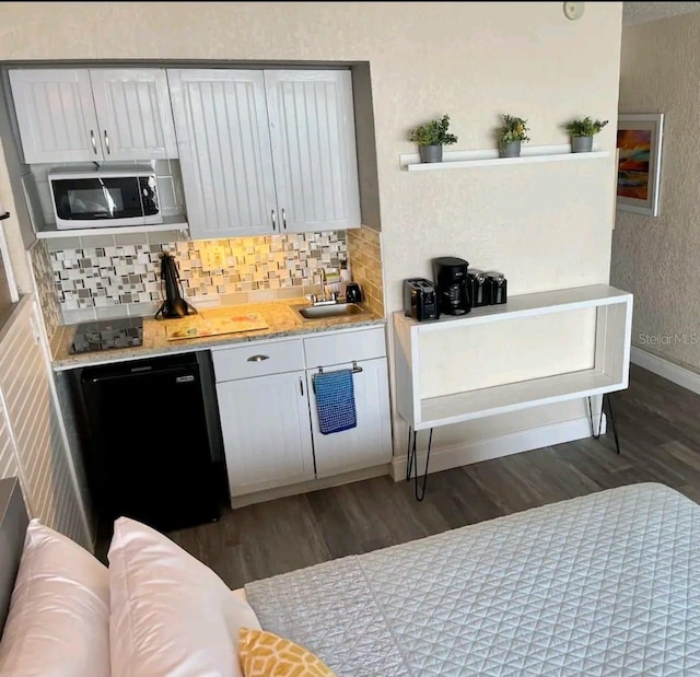 kitchen featuring dishwasher, tasteful backsplash, stainless steel microwave, dark hardwood / wood-style floors, and sink