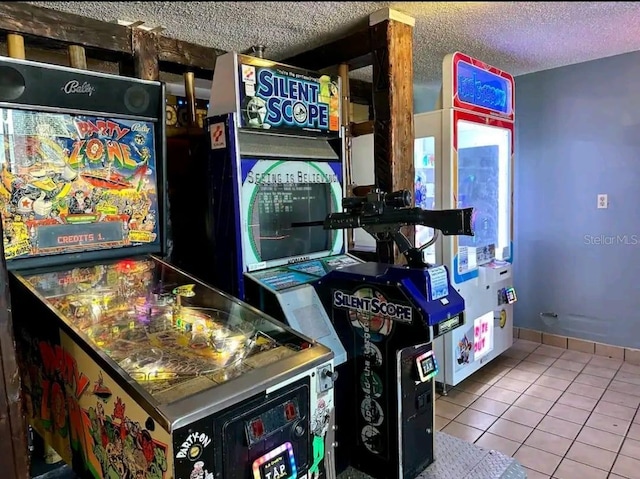 game room with a textured ceiling and light tile flooring