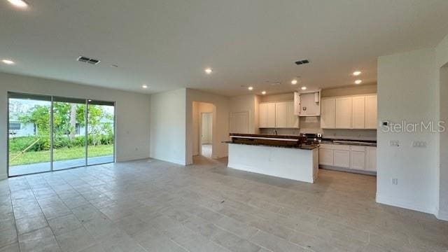 kitchen featuring white cabinets, a kitchen island, and light tile patterned floors