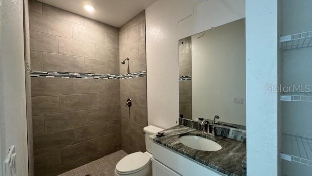 full bathroom with toilet, a shower stall, and vanity