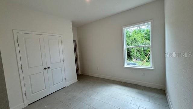 unfurnished bedroom featuring a closet and baseboards