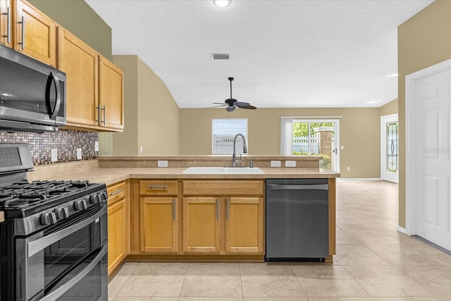 kitchen with kitchen peninsula, ceiling fan, sink, stainless steel appliances, and light tile flooring