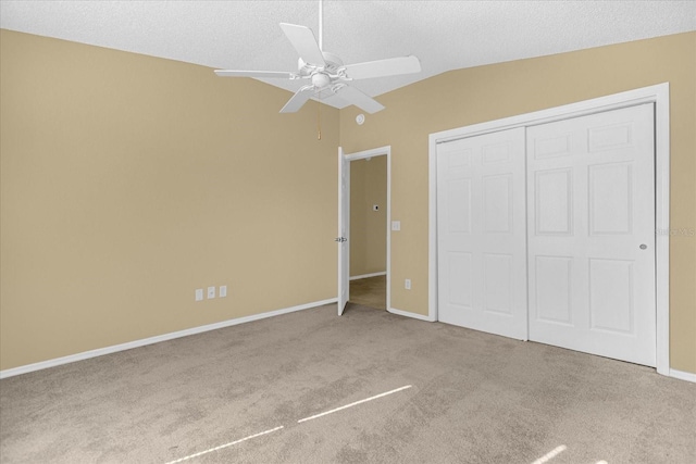 unfurnished bedroom featuring a closet, ceiling fan, vaulted ceiling, and light colored carpet