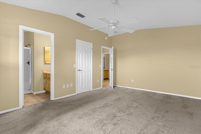 unfurnished bedroom with light carpet, lofted ceiling, ceiling fan, and ensuite bathroom