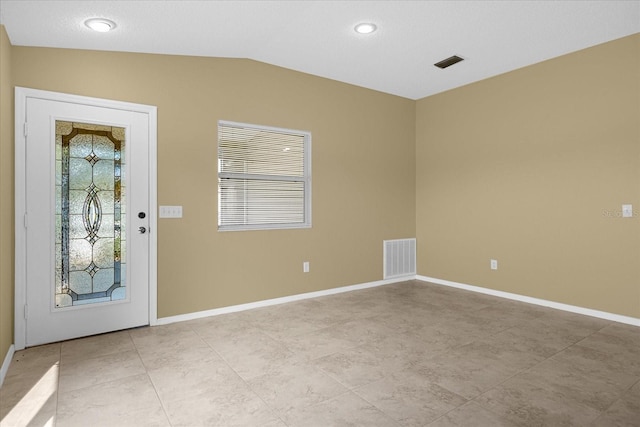 entryway with vaulted ceiling and light tile floors