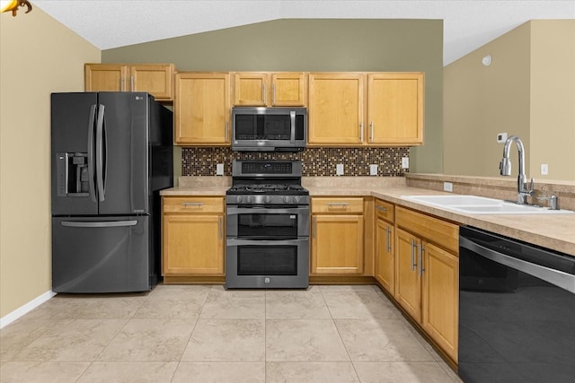 kitchen with vaulted ceiling, tasteful backsplash, stainless steel appliances, and sink