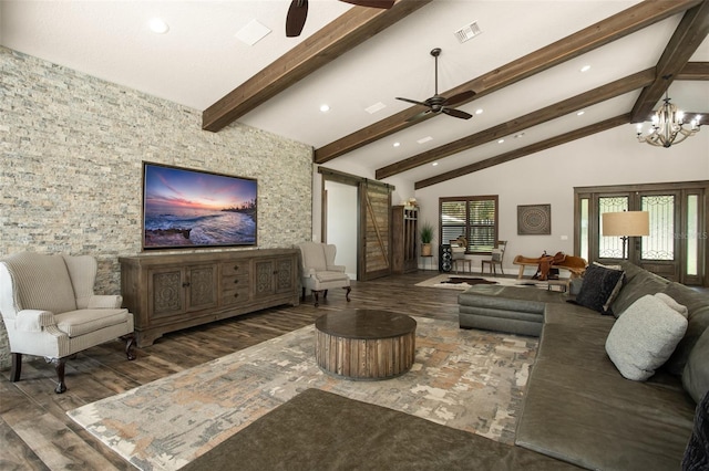 living room featuring lofted ceiling with beams, a barn door, ceiling fan with notable chandelier, and dark wood-type flooring