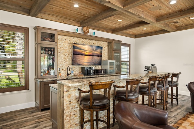 bar featuring a healthy amount of sunlight, wooden ceiling, dark wood-type flooring, and light stone counters