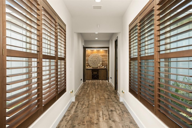 corridor with dark hardwood / wood-style flooring