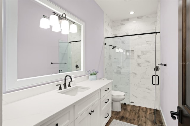 bathroom with toilet, a shower with door, hardwood / wood-style floors, and vanity