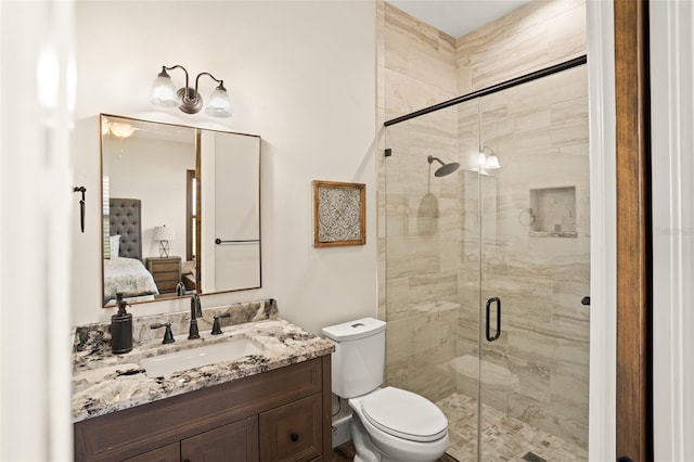 bathroom with toilet, a shower with door, and oversized vanity