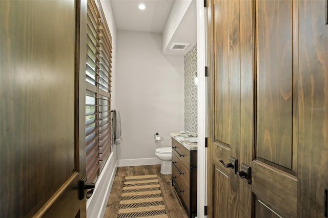 bathroom featuring wood-type flooring, toilet, and vanity