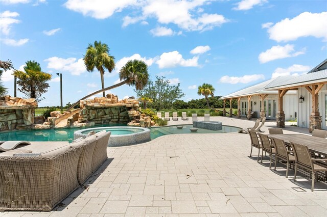 view of pool featuring a patio area and an in ground hot tub