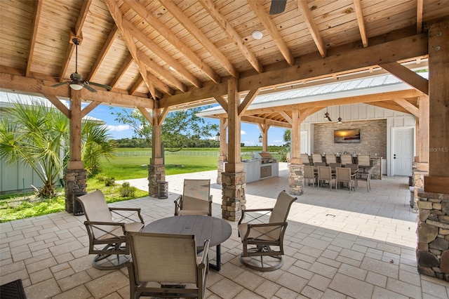 view of patio featuring a gazebo, an outdoor stone fireplace, and exterior kitchen