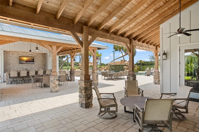 view of patio with an outdoor fireplace and ceiling fan