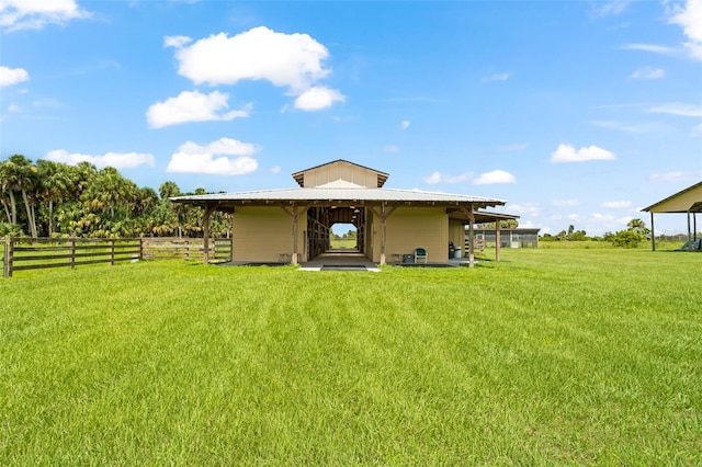 rear view of house featuring a rural view and a yard