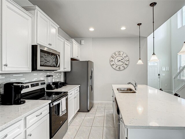 kitchen featuring pendant lighting, sink, backsplash, stainless steel appliances, and white cabinetry