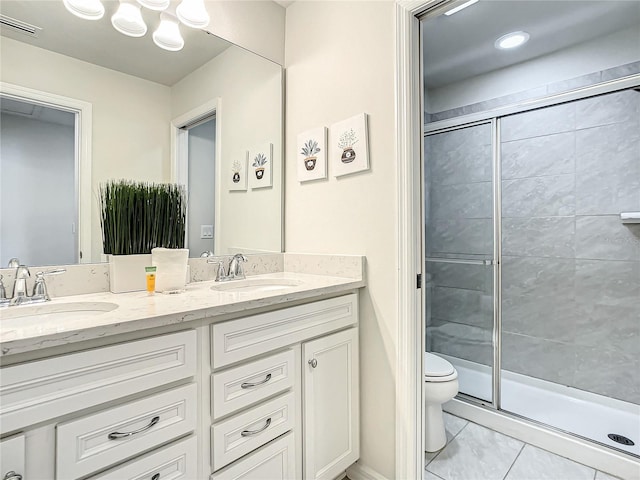 bathroom with dual sinks, a shower with door, tile flooring, toilet, and large vanity