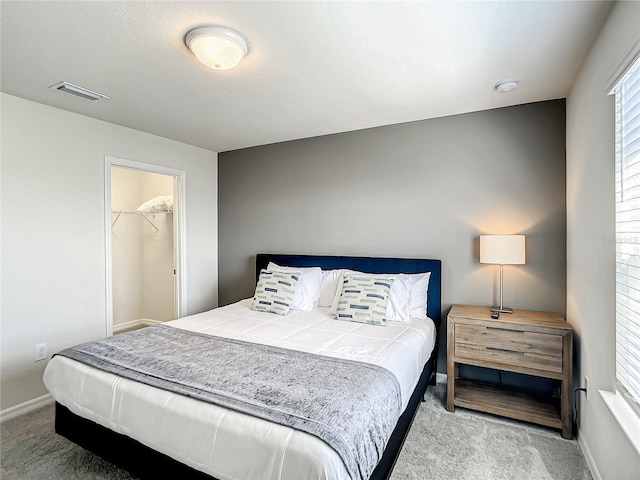 carpeted bedroom with a closet and a walk in closet