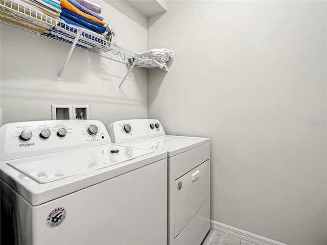 laundry room with hookup for a washing machine, independent washer and dryer, and light tile floors