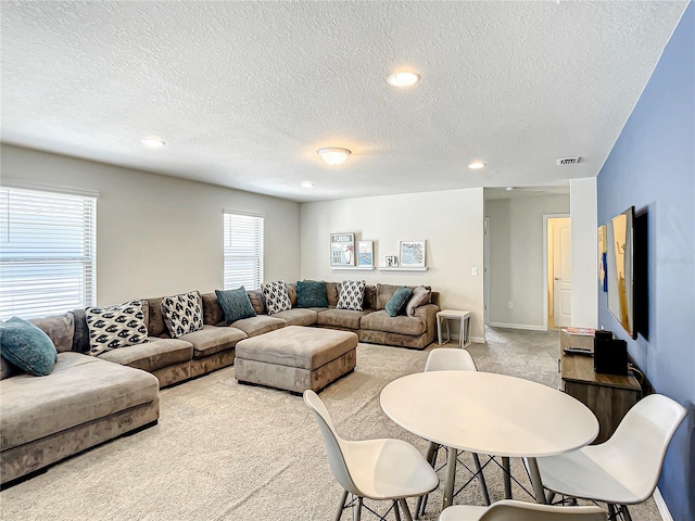 carpeted living room featuring a textured ceiling