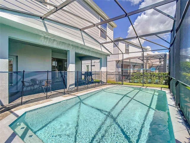 view of swimming pool featuring a patio area and a lanai