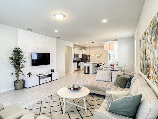 living room featuring sink and light tile flooring