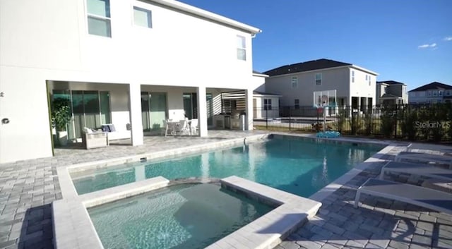 view of pool featuring an in ground hot tub and a patio