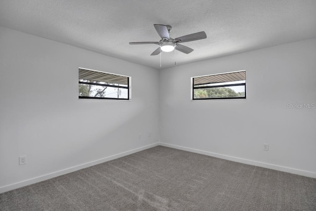 carpeted empty room with ceiling fan and a wealth of natural light