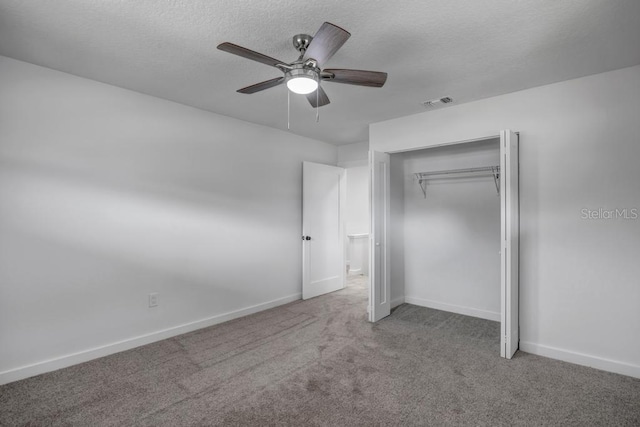 unfurnished bedroom featuring a closet, dark colored carpet, and ceiling fan