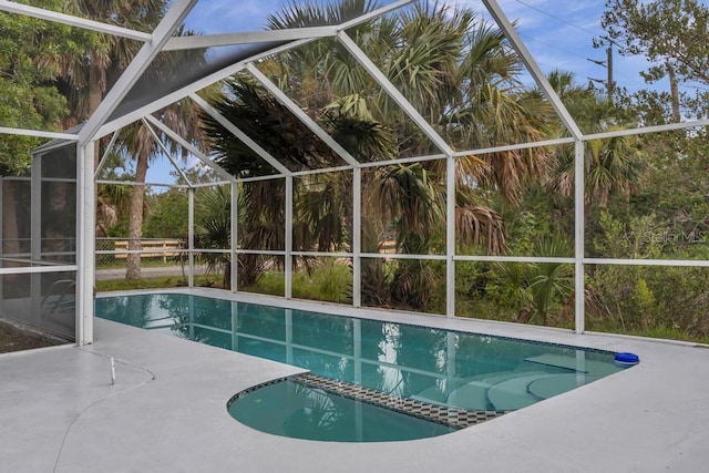 view of swimming pool featuring a patio area and glass enclosure