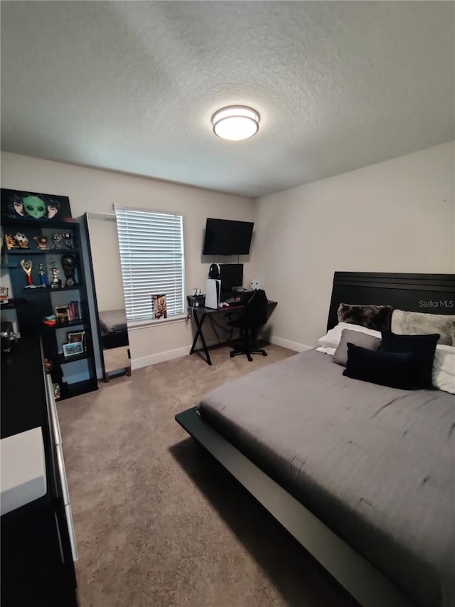 bedroom featuring light colored carpet and a textured ceiling