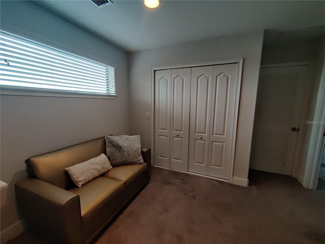 sitting room featuring dark colored carpet