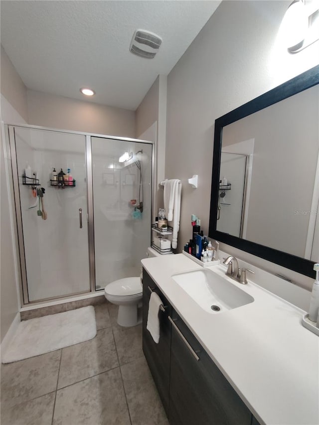 bathroom with an enclosed shower, toilet, vanity, and tile floors