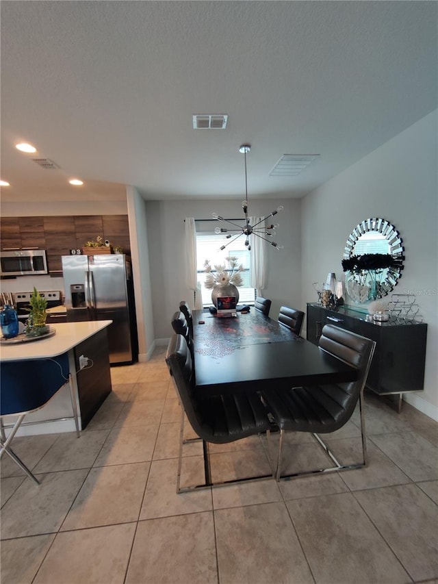 tiled dining space featuring a chandelier