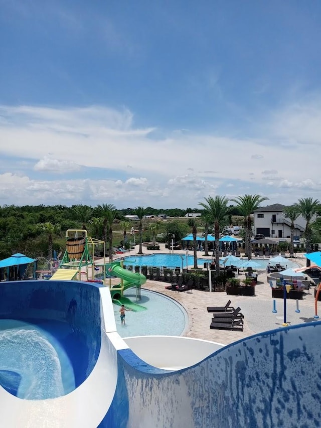 view of swimming pool featuring a water slide and a playground