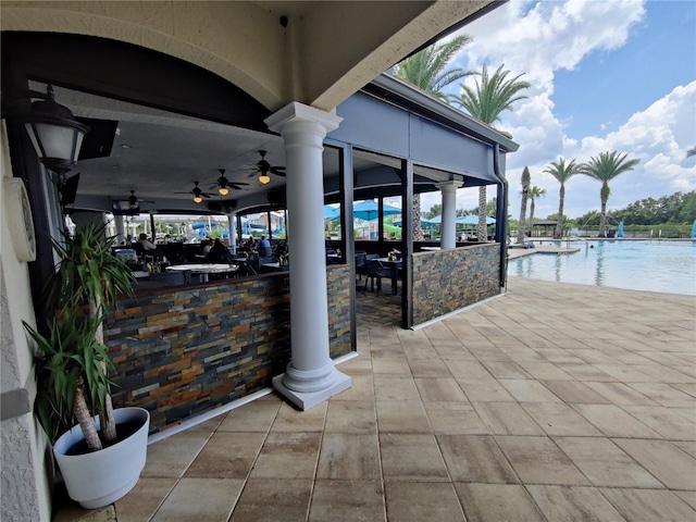 view of patio / terrace with ceiling fan and a community pool