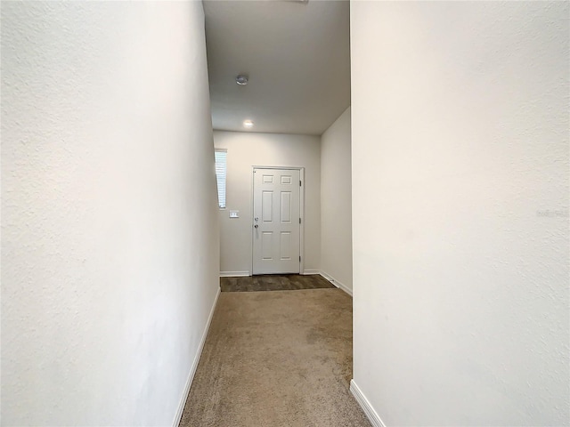 corridor featuring dark colored carpet