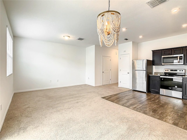 kitchen with hanging light fixtures, light wood-type flooring, a chandelier, stainless steel appliances, and dark brown cabinetry