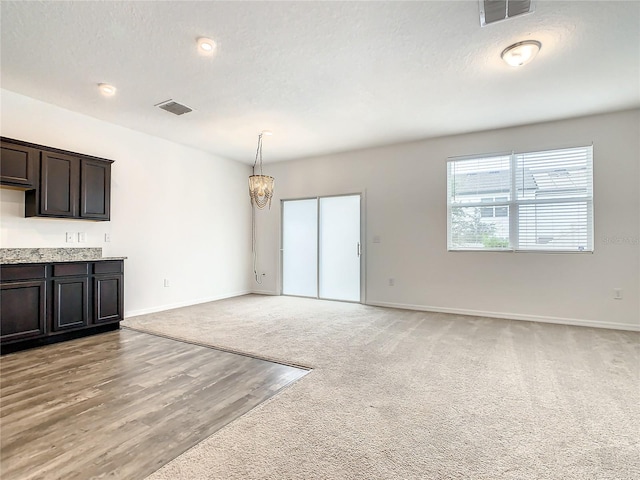 unfurnished living room with light carpet and a textured ceiling