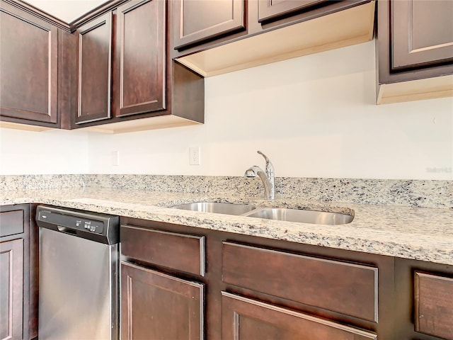 kitchen featuring light stone counters, dark brown cabinets, sink, and stainless steel dishwasher