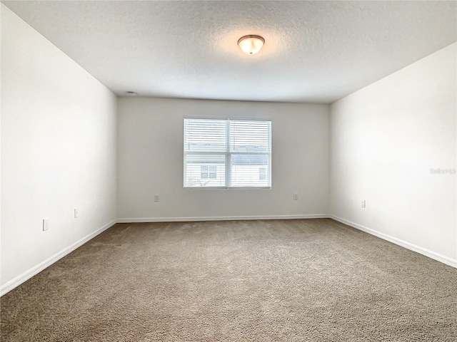 unfurnished room featuring carpet flooring and a textured ceiling