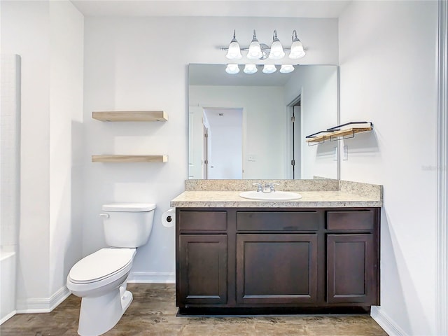 bathroom featuring toilet, hardwood / wood-style floors, and vanity