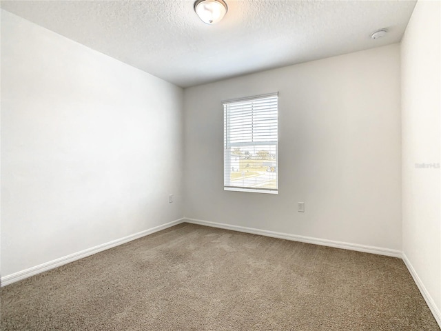 unfurnished room featuring carpet flooring and a textured ceiling