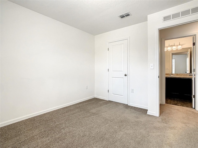 unfurnished bedroom with carpet floors and ensuite bathroom