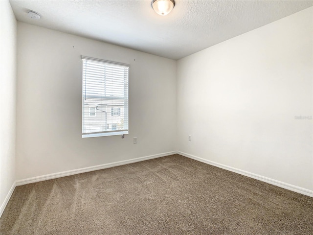 carpeted empty room featuring a textured ceiling