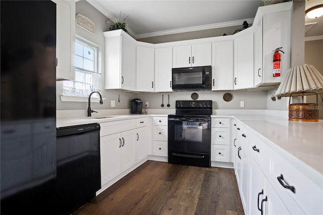 kitchen with sink, dark hardwood / wood-style flooring, white cabinets, black appliances, and ornamental molding