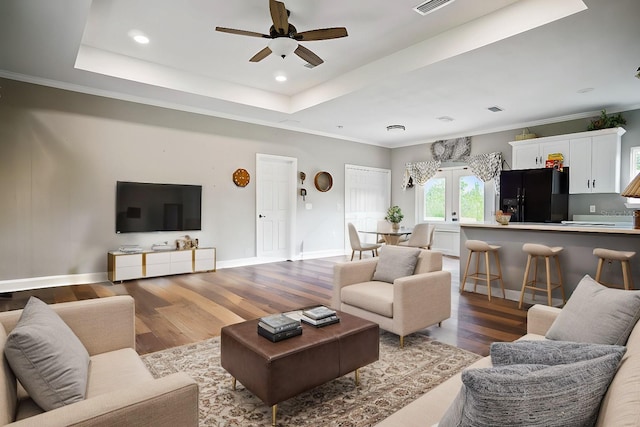 living room featuring french doors, dark hardwood / wood-style flooring, a raised ceiling, ceiling fan, and crown molding