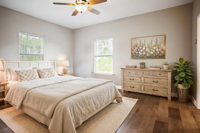 bedroom with multiple windows, ceiling fan, and dark hardwood / wood-style floors